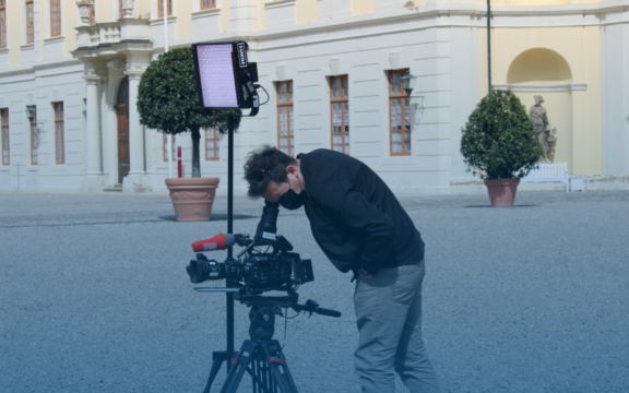 Aufgebautes Außenfilmset, Mann schaut in Kamera