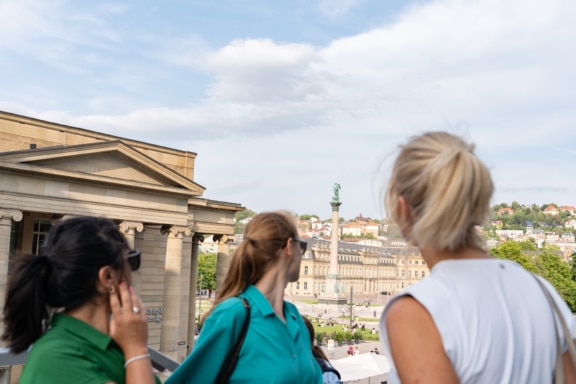 Drei Frauen schauen auf den Schlossplatz runter